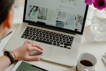 person using macbook pro on table